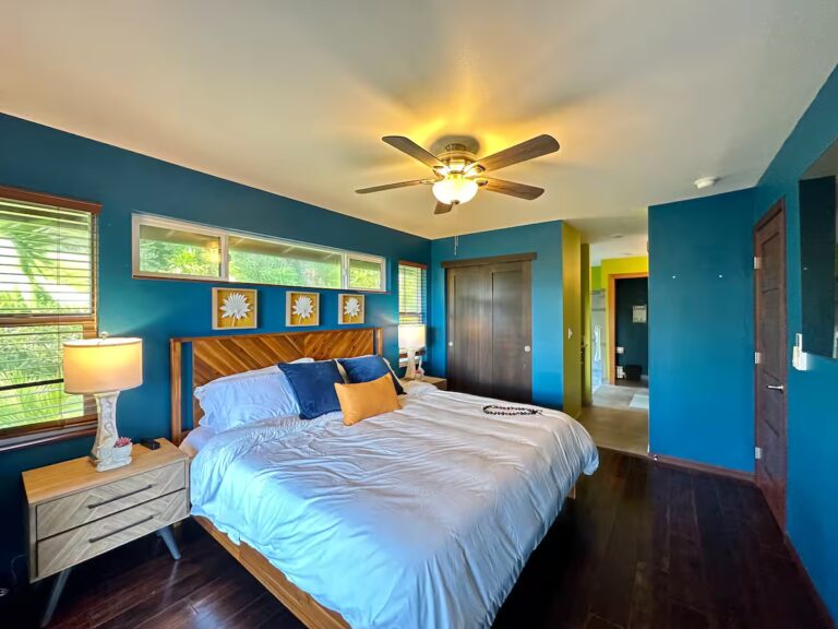 Blue bedroom with wood flooring and a ceiling fan at H5 Blue Lagoon of Kona Estate