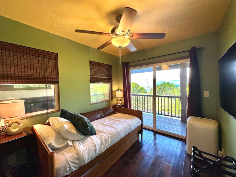 Green bedroom opening onto a balcony at H5 Blue Lagoon of Kona Estate