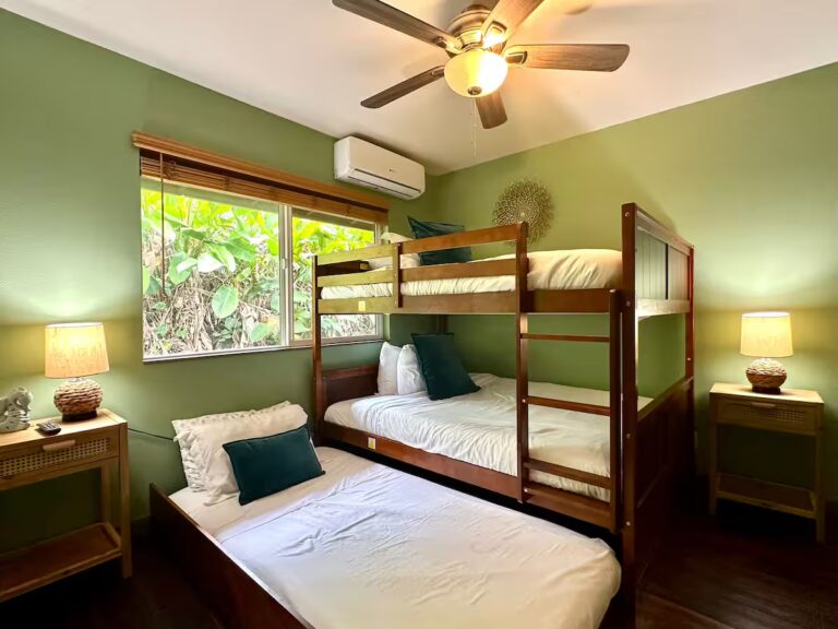 Green bedroom with bunk beds and an additional bed at H5 Blue Lagoon of Kona Estate
