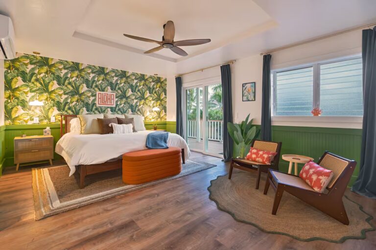 Bedroom with green botanical wallpaper and an adjoining sitting area at Spacious Kona Retreat