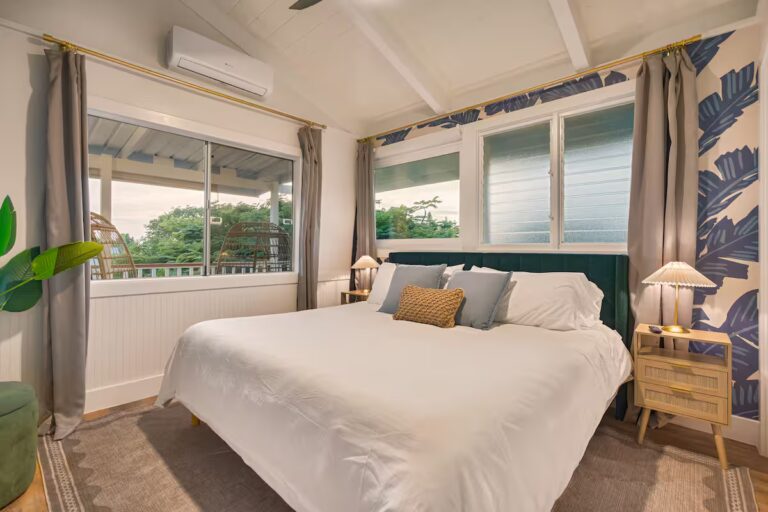 Bedroom with blue leaf wallpaper and corner windows at Spacious Kona Retreat