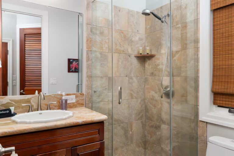 Bathroom vanity beside a glass-enclosed shower at Kona Luxury Estate