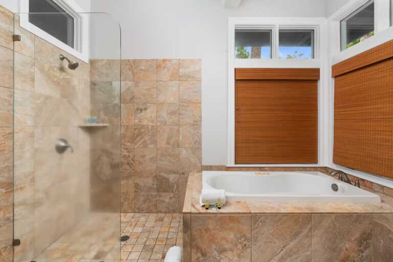 Bathroom with a glass shower beside a soaking tub at Kona Luxury Estate
