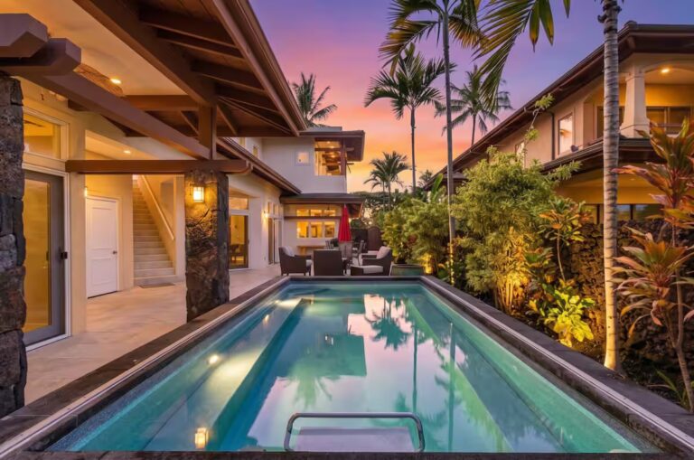 Illuminated swimming pool between the buildings at dusk at Kona Luxury Estate
