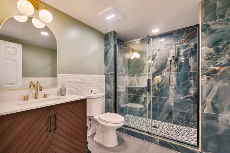 Bathroom with a glass shower and dark patterned tile at Spacious Kona Retreat