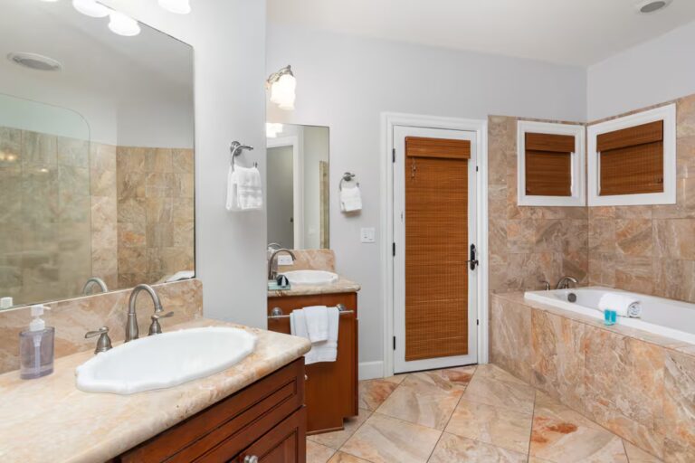 Bathroom with twin sinks and a tiled bathtub at Kona Luxury Estate