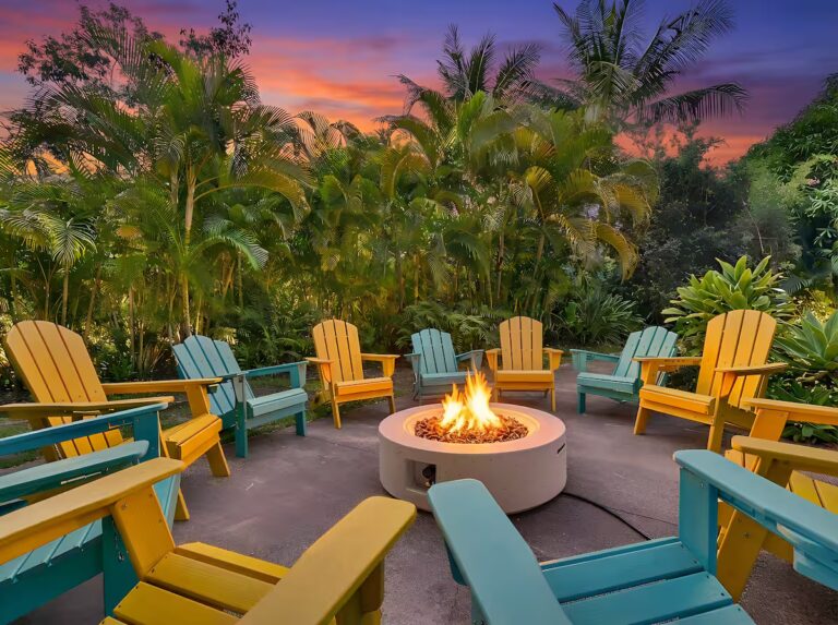 Colorful outdoor chairs arranged around a fire pit at Spacious Kona Retreat