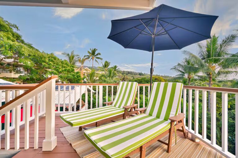 Striped lounge chairs and a sun umbrella on the deck at Spacious Kona Retreat