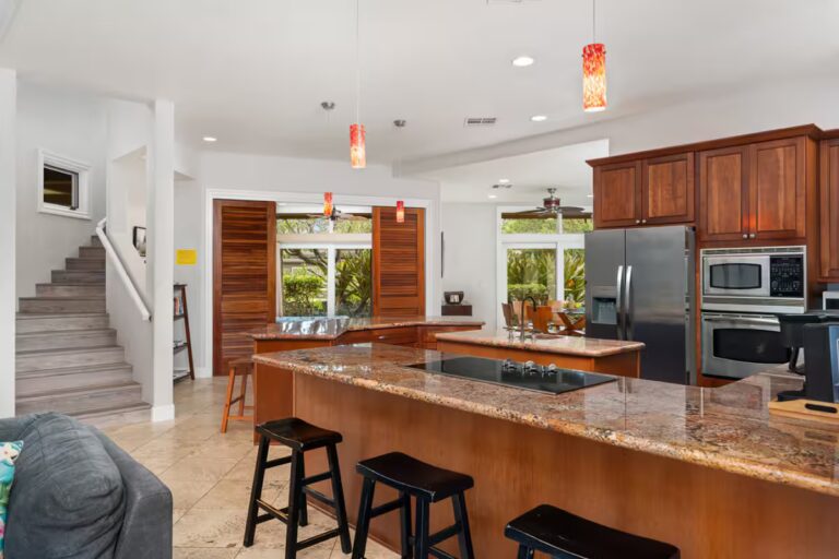 Kitchen island with stools beside the staircase at Kona Luxury Estate