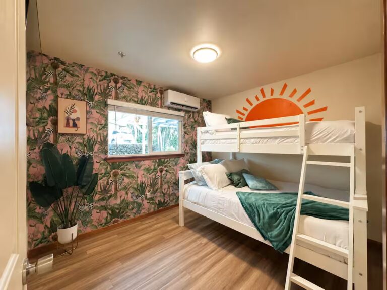 Bunk bedroom with tropical wallpaper and a sunrise mural at HI8 Kona vacation home