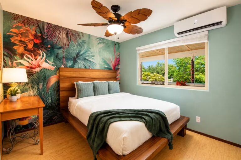 Bedroom with a floral mural and a green throw blanket at Kona Retreat with Hot Tub, Tiki Bar and Pickleball