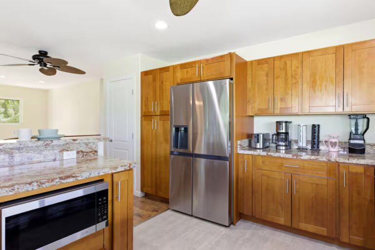 Kitchen with wood cabinets and a stainless-steel refrigerator at H12 Kona home