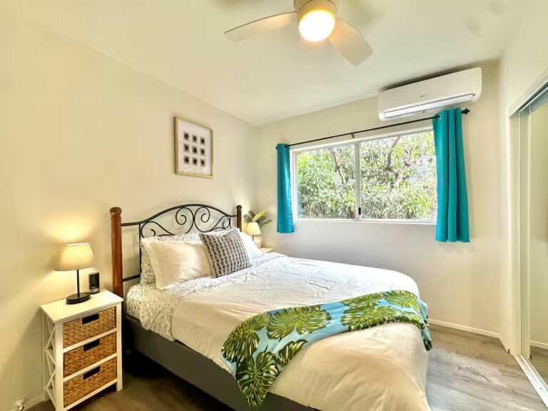 Bedroom with turquoise curtains and tropical bedding at H7 Kona home