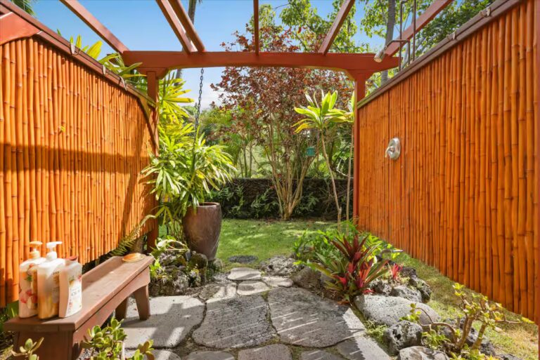 Outdoor shower with bamboo screening and tropical plants at H6 Dolphin Bay Estate