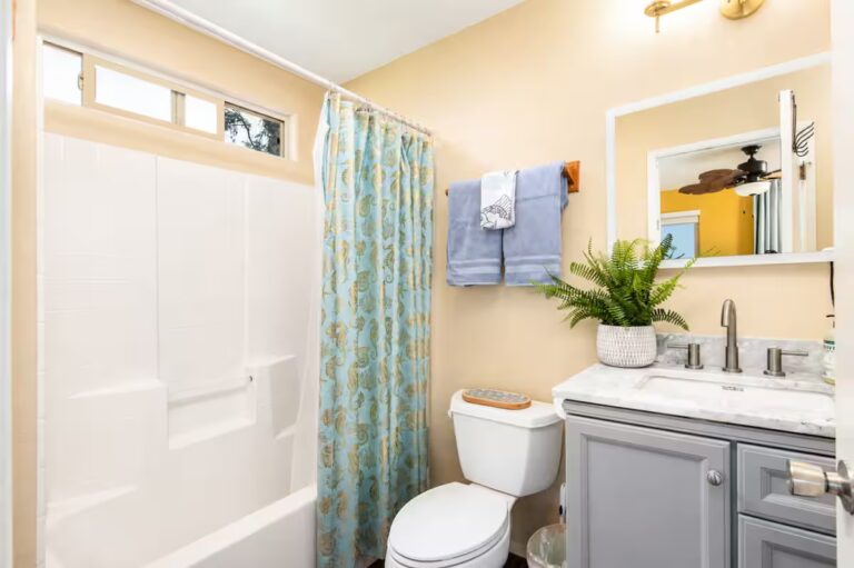 Bathroom with a gray vanity and turquoise shower curtain at Kona Retreat with Hot Tub, Tiki Bar and Pickleball