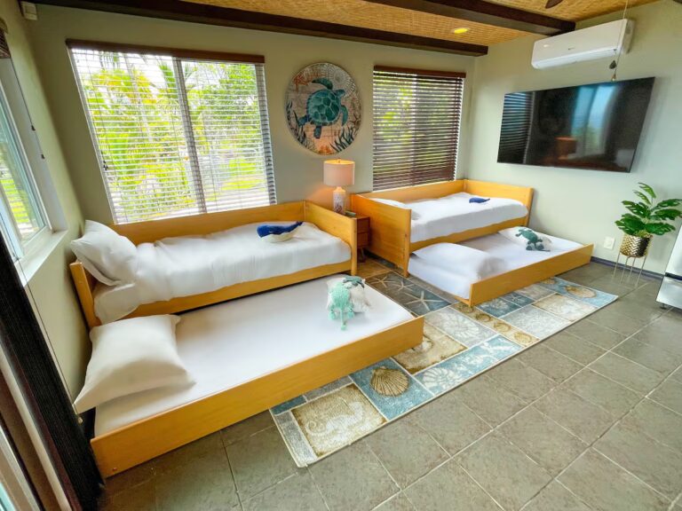 Bright sleeping area with daybeds and a wall-mounted television at H4 Kona home