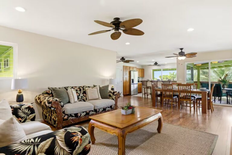 Open living and dining area with tropical-patterned sofas at H12 Kona home
