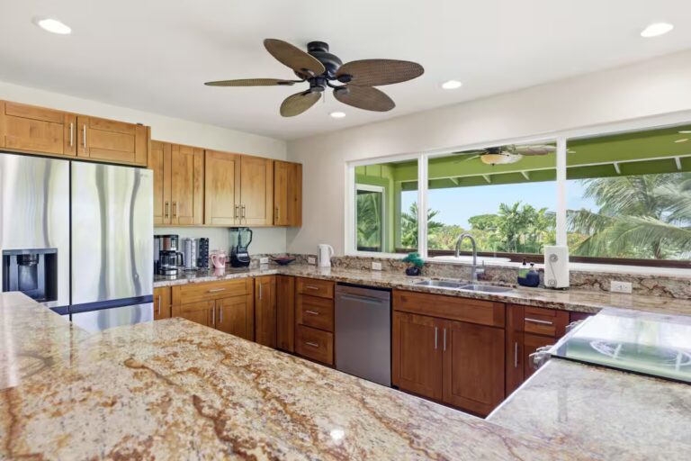 Kitchen with stone counters and garden-facing windows at H12 Kona home