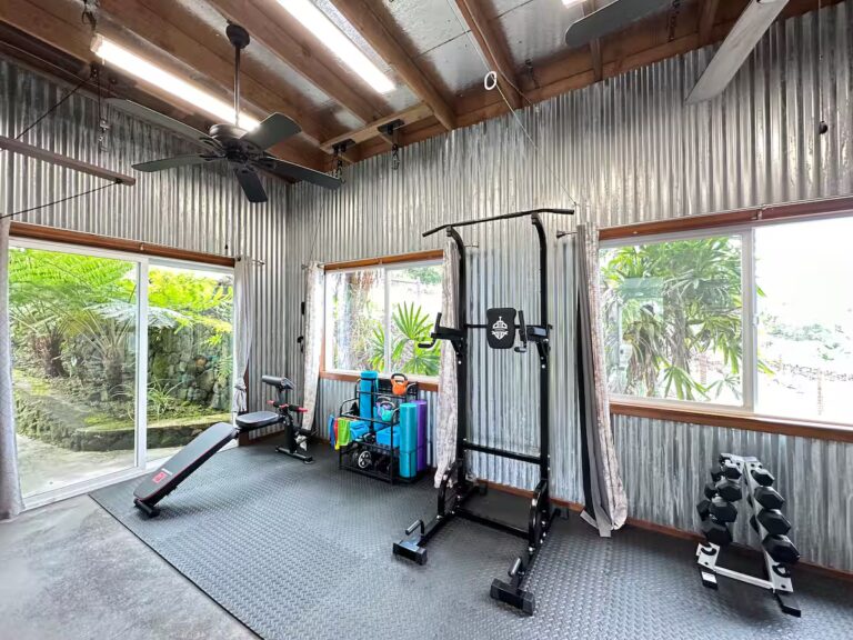 Exercise room with a weight rack, dumbbells and a bench at H4 Kona home