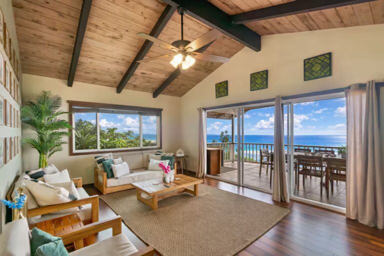 Living room opening onto an ocean-facing balcony at H4 Kona home