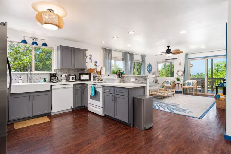 Gray kitchen opening onto the dining area at Kona Retreat with Hot Tub, Tiki Bar and Pickleball