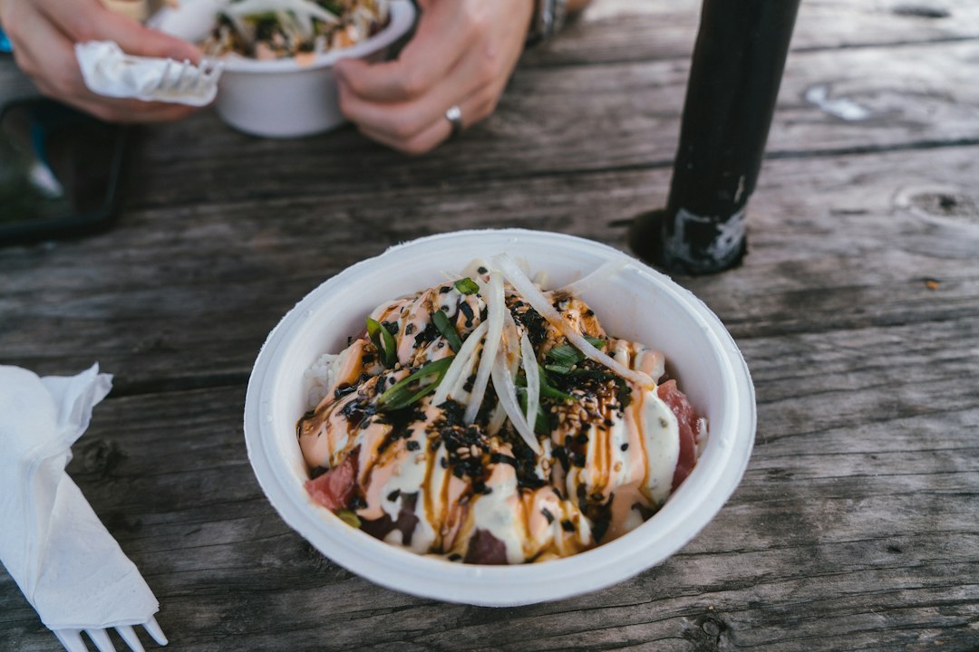 Bowl of food with fish, vegetables and sauce