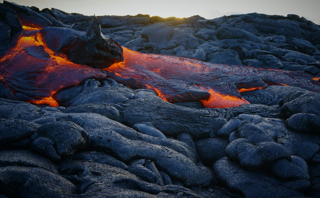 Archival photograph of lava flowing across dark volcanic rock