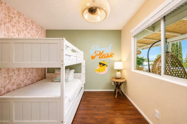 Bunk bedroom with floral wallpaper and an aloha wall decoration at Kona Retreat with Hot Tub, Tiki Bar and Pickleball