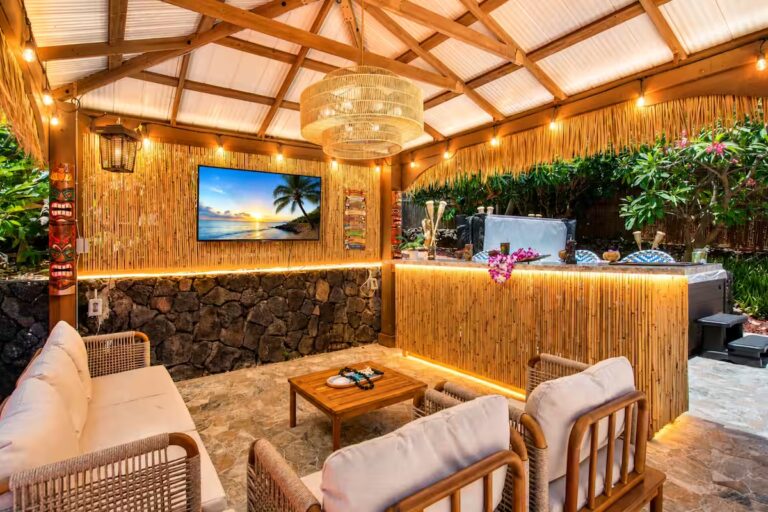 Illuminated tiki bar with a television and lounge seating at Kona Retreat with Hot Tub, Tiki Bar and Pickleball