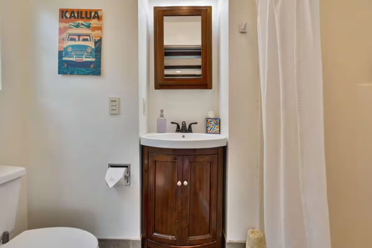 Small bathroom with a wood vanity and shower curtain at H4 Kona home