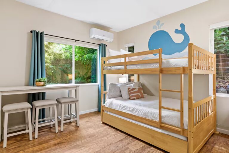 Bunk bedroom with a blue whale mural and window-side desk at H12 Kona home