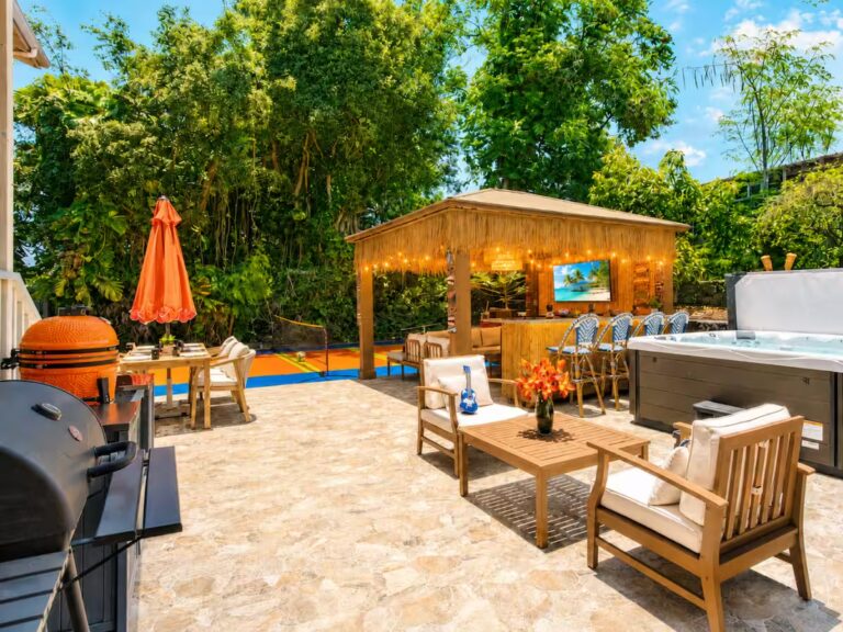 Outdoor patio with grills, seating, a hot tub and tiki bar at Kona Retreat with Hot Tub, Tiki Bar and Pickleball